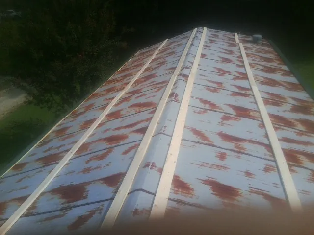 Rusted metal roof panels with new wood purlins before replacement — Storm Damage Roof Repair in East Hanover by Roofing Brothers