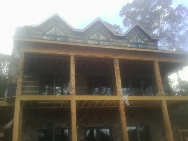 Dormers and porch framing on a large log home under construction — Roof Coating work by our crew in East Hanover