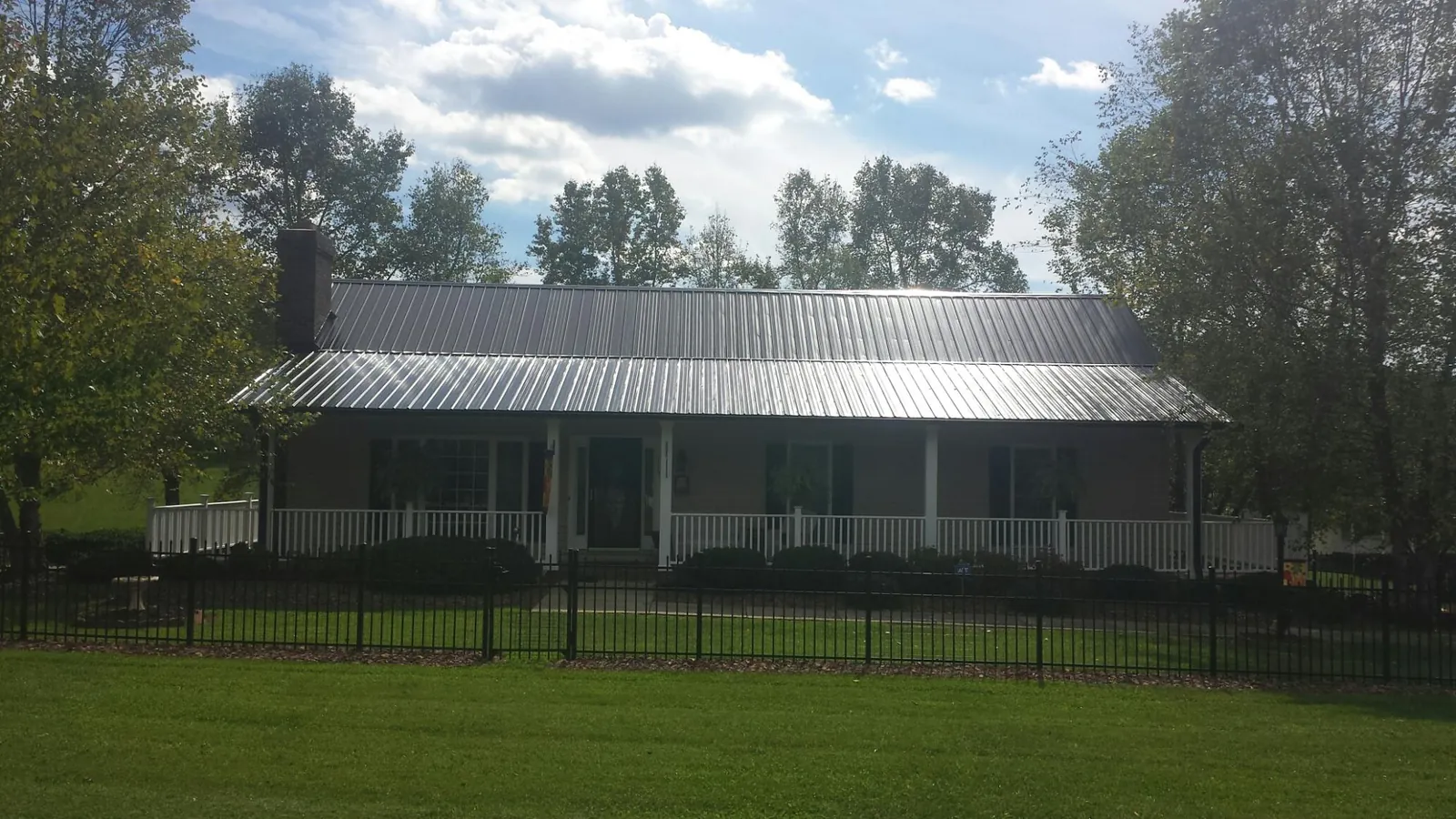 Gray metal roof on a brick ranch with a full width front porch — Gutter Guard Installation work by our crew in East Hanover