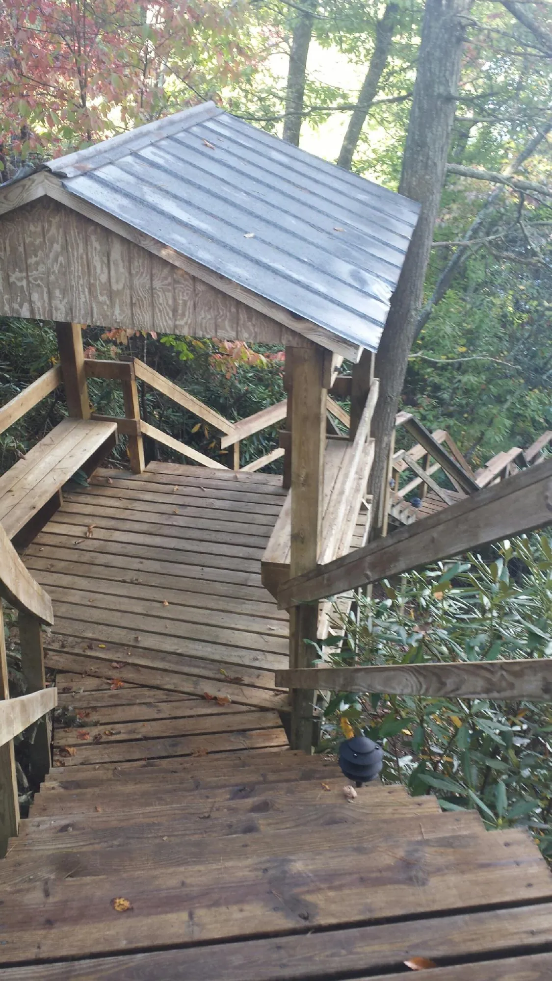 Metal roofed shelter over wooden steps on a wooded walkway — Skylight Repair & Installation work by our crew in East Hanover